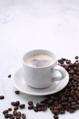 Beyaz arka planda kavrulmuş fasulye ile kahve fincanı
