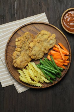 Patatesli kızarmış tavuk ve ahşap arka planda yeşil bezelye.