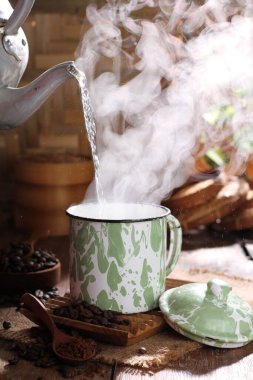 coffee cup with hot chocolate and cinnamon sticks on wooden background