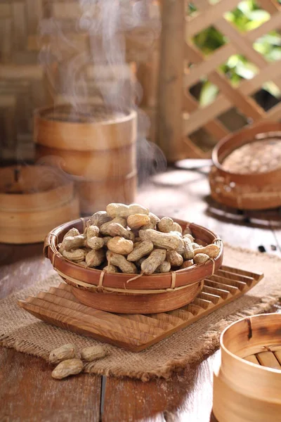 stock image roasted peanuts in a wooden bowl on a rustic background