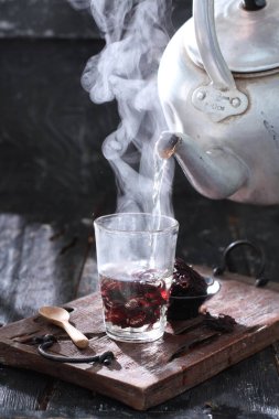 Bir fincan kahveyle bir bardak viski ve ahşap bir arka planda.