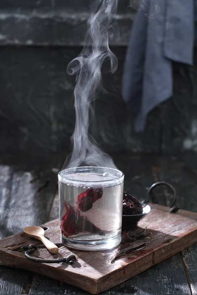 stock image hot tea with a glass of red wine on a wooden background