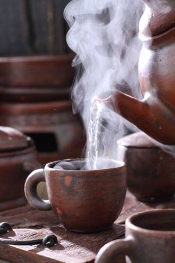 Eski ahşap çaydanlık ve bir fincan çay. 