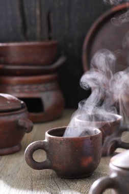 Bir kaşık ve siyah arka planlı ahşap bir fincanı kapat. 
