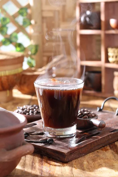 コーヒー豆とコーヒーカップ付きの木の背景にブラックコーヒー — ストック写真