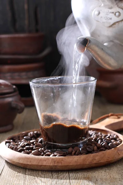 木製の背景にコーヒー豆とホットドリンク — ストック写真