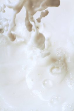 Süt sıçramaları olan soyut beyaz arkaplan, makro 