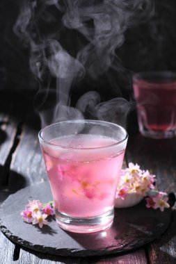 aromatik pembe gül çayı, cam fincanda, siyah arka planda, seçici odak 