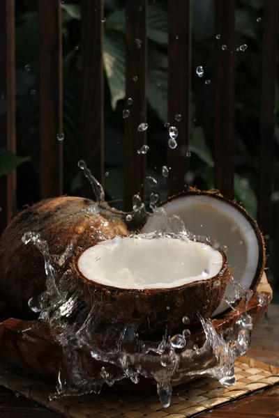 coconut milk with tropical fruits on wooden table