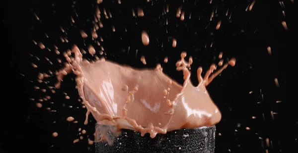 검은색 배경에 유리에 우유와 초콜릿을 튀기는 — 스톡 사진
