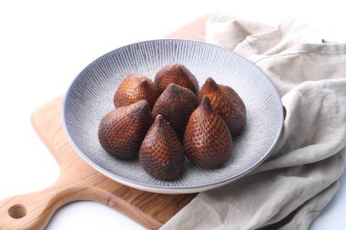 Beyaz arka planda tatlı ve ekşi bir tadı olan yılan derisi meyvesi ya da