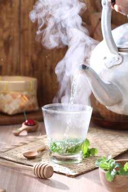 Tahta arka planda bir fincan sıcak çay