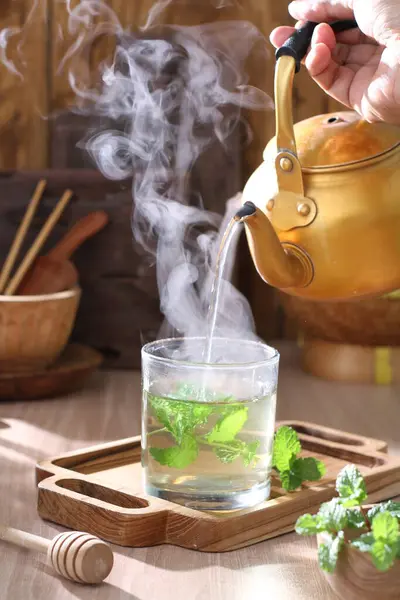 tea with green leaves and teapot