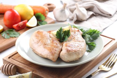 Ispanaklı tavuk göğsü ve beyaz tabakta elma.