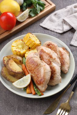 Kızarmış tavuk göğsü, patates, domates ve sebzeli.