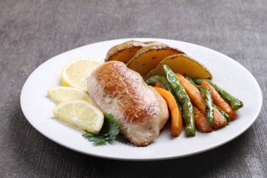 Kızarmış tavuk, patates, sebze ve beyaz tabakta salata.