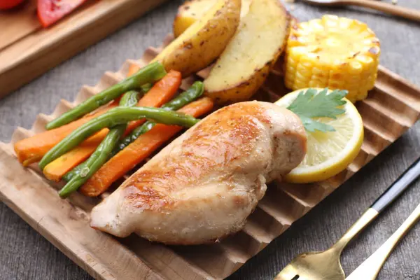 Tahta masada sebzeli ızgara tavuk.