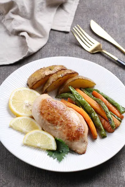 Lezzetli kızarmış tavuk fileto ve sebzeli tabak. Masanın üzerinde, yakın plan.