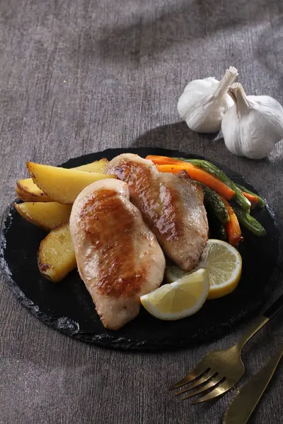 Beyaz tabakta sarımsaklı patates ve biberiye.