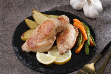 Limonlu ve sarımsaklı kızarmış tavuk bacağı.