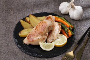 Patatesli kızarmış tavuk ve siyah arka planda sarımsak.