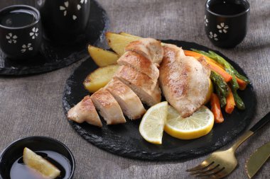 Izgara tavuk budu ve siyah tabakta patates. sağlıklı yiyecekler