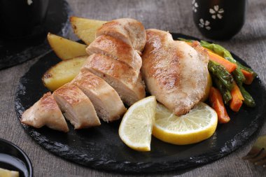 Limonlu ızgara tavuk budu, yeşil kuşkonmaz ve taze limon. sağlıklı yiyecekler.