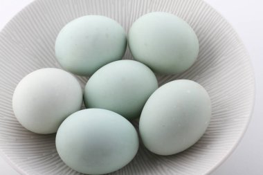 Bir tabak taze mavi tavuk yumurtası ve beyaz tavuk yumurtası. Yakın plan.