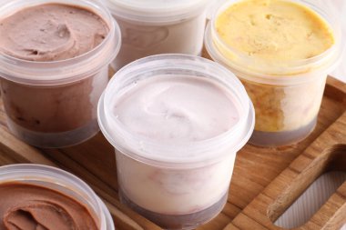 Tahta bir masanın arka planında farklı çikolata çeşitleri olan dondurma.