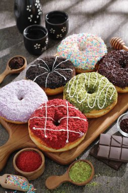 beyaz arka planda bir kutuda farklı çörekler ve renkli şekerler