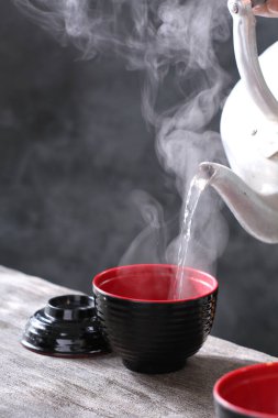 Koyu gri arka planda beyaz fincanda sıcak kahve