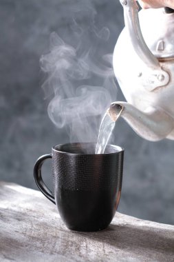 Buharlı bir fincan sıcak siyah çay.