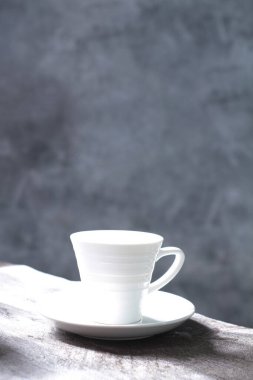 Boş kahve fincanı ve çay tabağı masanın üstünde.