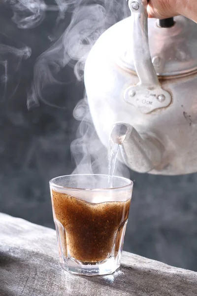 Siyah Arka Planda Kaşıkla Bir Fincan Siyah Çay — Stok fotoğraf