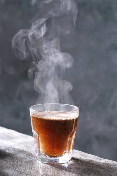 coffee cup with black smoke and smoke on a dark background.