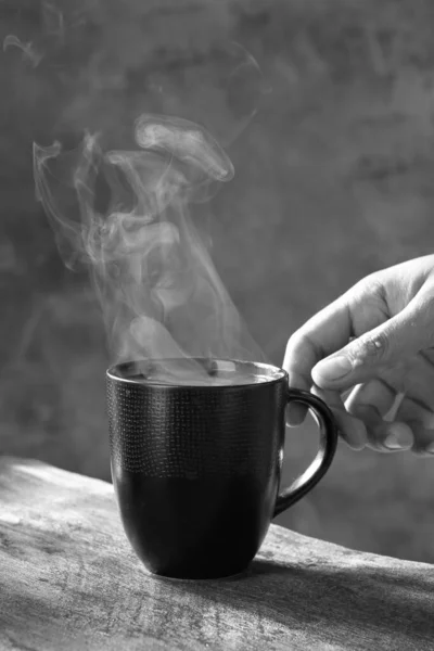 黑黑的背景上端着一杯热茶 — 图库照片