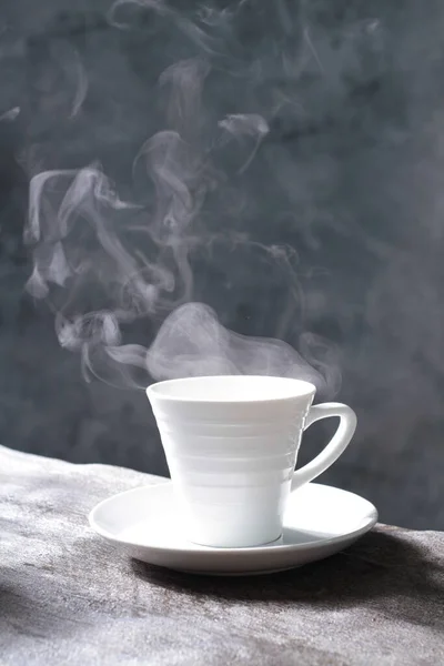 cup of coffee with smoke on dark background