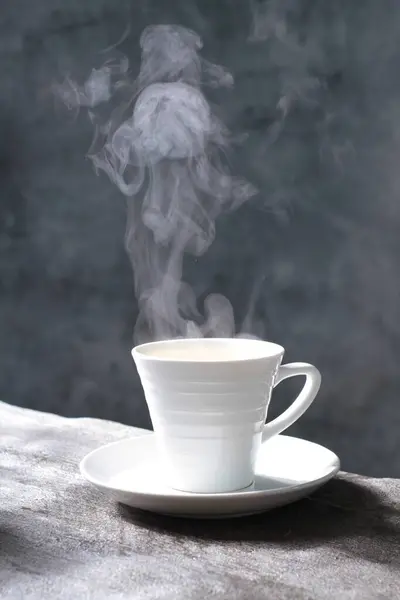 hot coffee in cup with steam and smoke