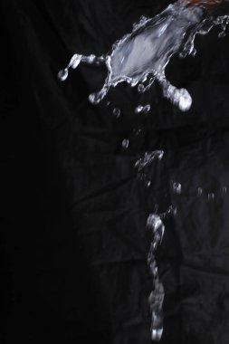 Su bardağa bir damla sıvı damlatıyor..