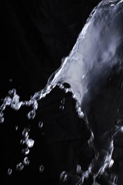 Siyah arka planda su sıçraması. Su yüzeyine su damlası. soyut arkaplan