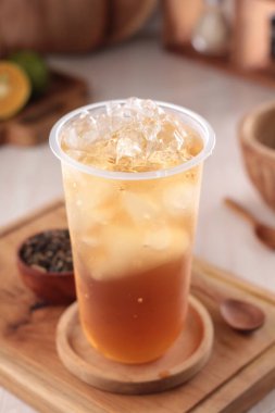 Bir bardak buzlu çay ve ahşap masada çay.