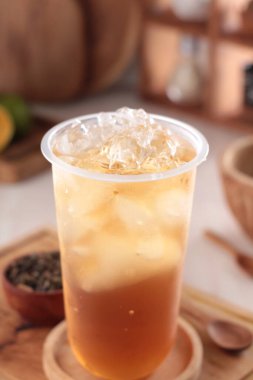 Bir fincan buzlu kahve ve ahşap bir masada bir bardak süt.