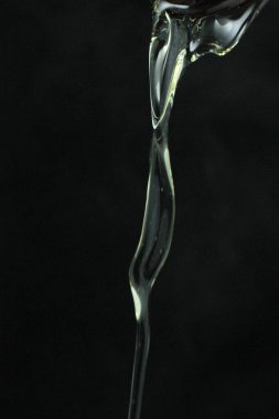 Siyah arkaplanda yağ damlasını kapat