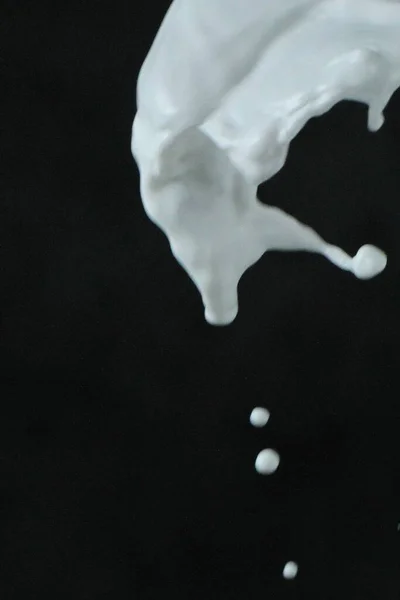 ミルクが黒い背景に飛び散る — ストック写真