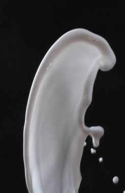 Sıçrayan ve siyah arkaplanı olan beyaz kozmetik ürünü