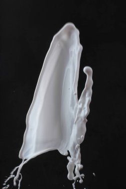 Siyah arkaplanda izole edilmiş süt damlası