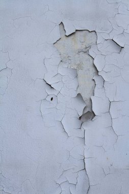 Eski gri beton duvardaki çatlamış beyaz boya dokusu.