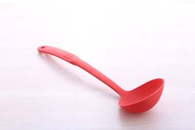 Beyaz tahta arka planda kırmızı plastik kaşık