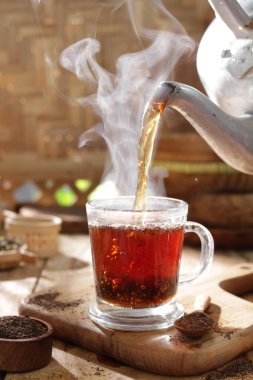 Tarçınlı sıcak çay ve ahşap masada şeker.