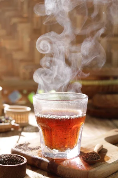 hot tea in glass cup and smoke with steam